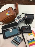 Three instant cameras with cases to Polaroid one