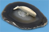 Moose antler carving of a beluga whale on an agate