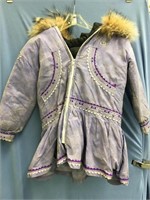 A used, child's handmade parka with wolf trim, qui