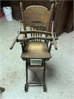 Old wood high chair with cane seat and wheels