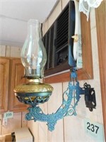 Vintage kerosene lamp in cast iron wall backet,