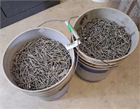 A 5 gallon pail of 2.5 inch nails and another 5