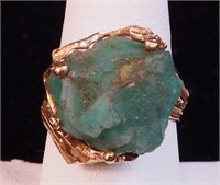 A rough-cut emerald set in a unmarked yellow
