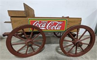 Wooden wagon with Coca Cola sign on the side.