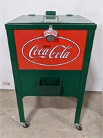 Standing Coca Cola cooler on wheels with bottle