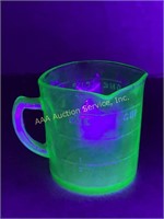 Glowing depression glass uranium measuring cup.