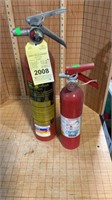 Two fire extinguishers, one in the green
