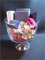 Container of costume jewelry including faux