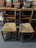 Two Antique chairs with book racks in the back,