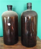 (2) Round glass jugs. Measures: 13.5" tall.