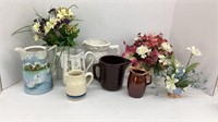 Various glass pitchers and fake flower decor