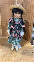 Porcelain faced doll on stand