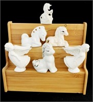 Ceramic unicorn and angel figurines on a wooden di