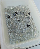 Container of glass marbles and stones.