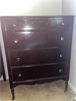 Four drawer wooden chest of drawers on casters