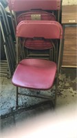 8 red plastic and metal folding chairs