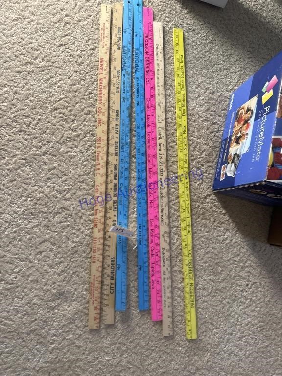 7 ADVERTISING YARD STICKS, IN LIVING ROOM