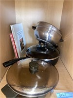 Contents in cabinet, pots and cook books.