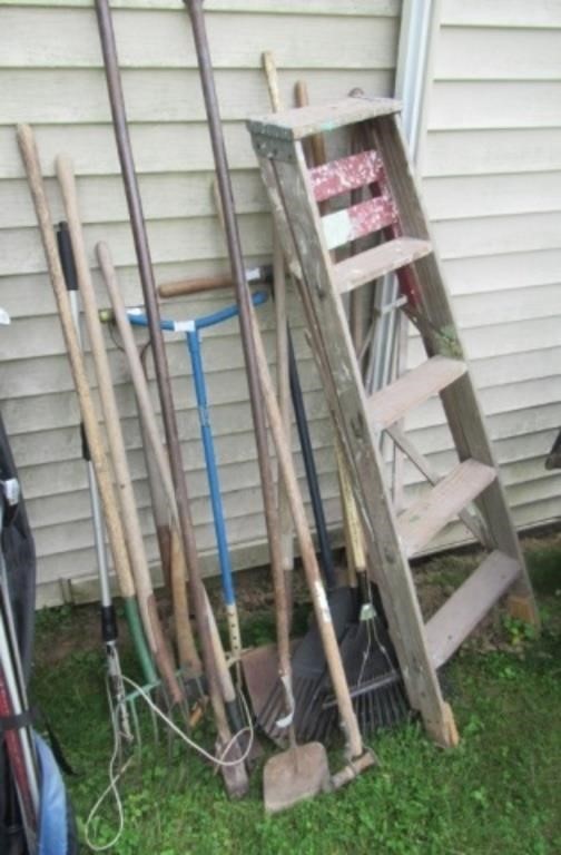 Group of yard tools includes pitch fork, rake,