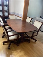 DINING ROOM TABLE WITH  6 PADDED  ROLLER CHAIRS.