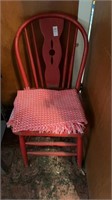 Small red chair with small red and white rug