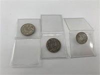Three silver Canadian coins: two 50 cent pieces an