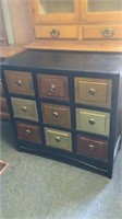 Black chest with 9 multi-colored drawers