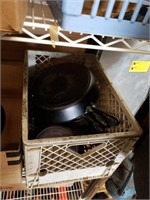 Crate of cast iron cookware