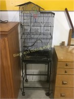 Wire bird cage on a rolling cart