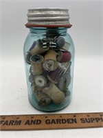 Bowl blue quart jar filled with wooden thread