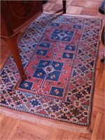 Woven wool throw rug in reds, blues