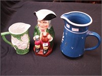 Three china pitchers: one is an 8" Toby jug