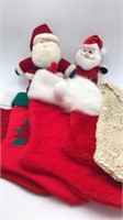 Five Christmas stockings, two stuffed Santas