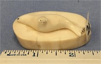 2 1/4" white ivory seal carving, laying on a secti