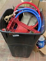 Garbage can full of miscellaneous garage items
