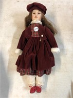 Collectible doll with red velvet coat and hat