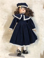 Collectible doll with blue dress and blue hat on