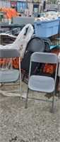 Five black and gray folding chairs