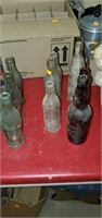 Lot of glass bottles,  some Coca-Cola,  one from
