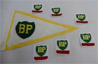GROUPING OF 6 BP BADGES & SMALL NYLON FLAG