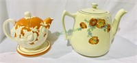 Two antique orange and white tea pots, one with a