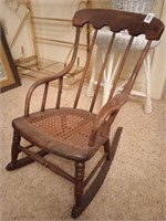 Antique child's rocking chair with woven bottom.