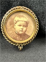 C clasp vintage brooch with a child photo.