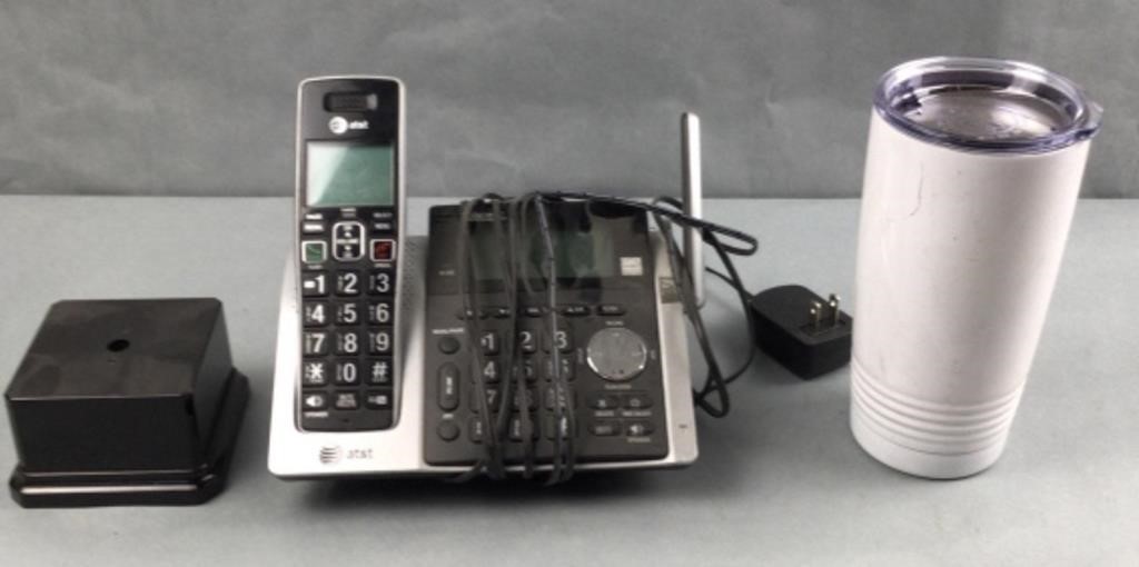 White cup, cordless home phone, and trophy base