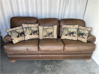 Brown leather sofa with nail head trim & hide a