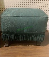Small vintage footstool with a green upholstery