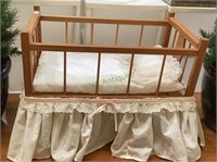 Small wooden baby doll crib with bedding