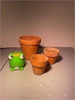 three terracotta pots and one green frog