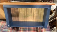 Small display cabinet with three coat hooks.