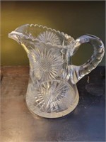 8" CRYSTAL PITCHER W/A CHIP UNDER THE BOTTOM